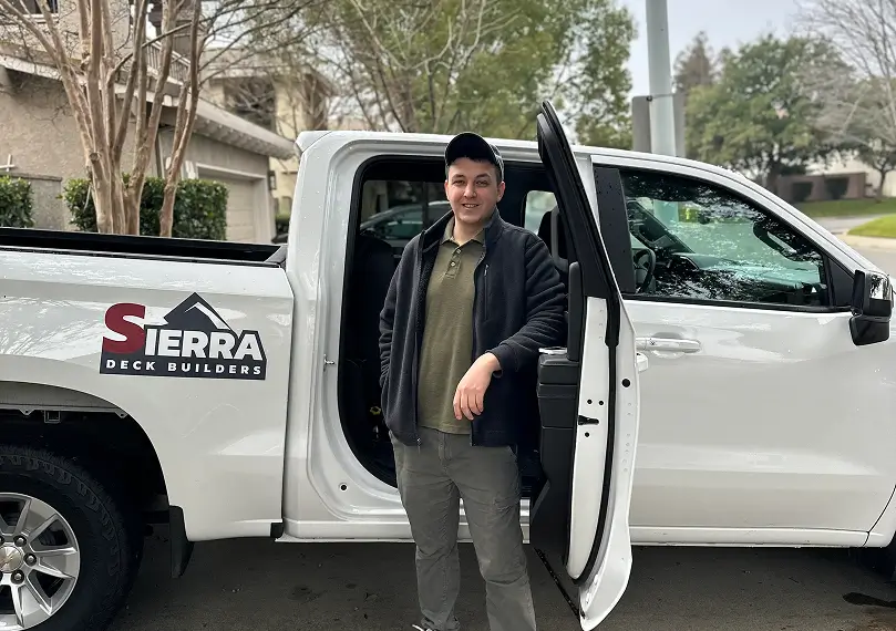 Nick Trayze stays in front of a truck with Sierra Deck Builders logo